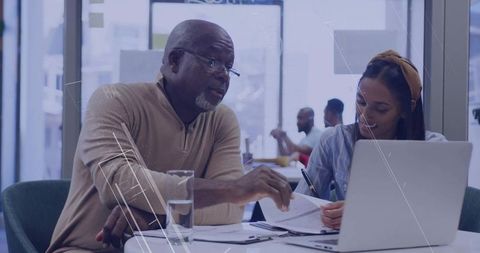 Collaboration Between Senior Mentor and Young Professional at Modern Office