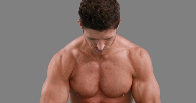 A muscular Caucasian man is showcased focusing on his upper body strength and definition, with copy space. His physique highlights dedication to fitness and bodybuilding.