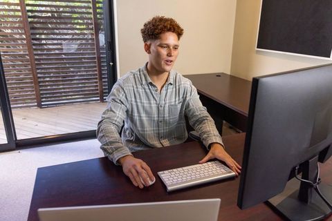 Man Working at Modern Home Office Desk on Computer