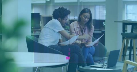 Professional Team Reviewing Documents in Modern Office Lounge