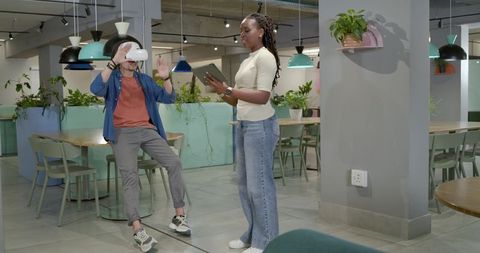 African American Team Testing VR Headset While Woman Holding Tablet in Coworking Hub