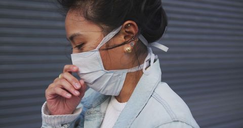 Asian Woman Wearing Mask Standing in Urban Street
