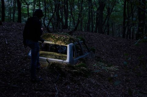 Mysterious Scene of Abandoned Car in Forest at Night