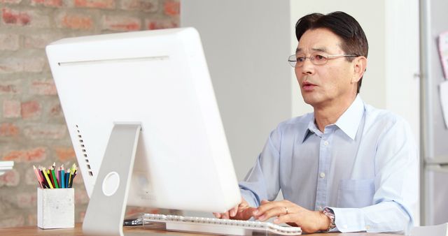 Middle Aged Businessman Working at Computer in Home Office - Download Free Stock Images Pikwizard.com