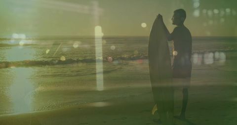 Surfer holding longboard at golden hour silhouette on shoreline with sun-glow bokeh