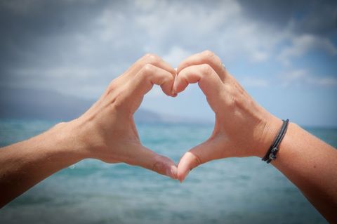 Hands Forming Heart Shape on Seaside