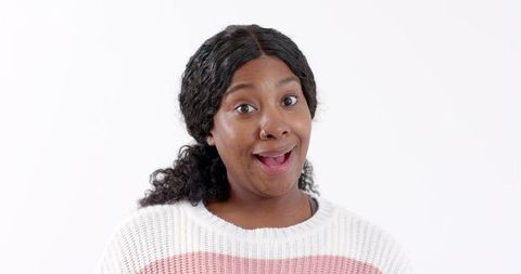 Surprised woman wearing white sweater against white background