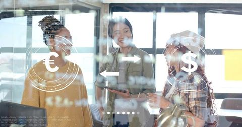 Women discussing euro to dollar exchange on digital tablet in modern collaborative office