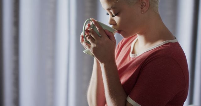 Young African American Woman Sipping Hot Beverage in Morning Light - Download Free Stock Images Pikwizard.com