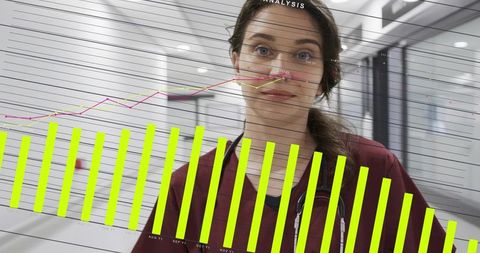 Standing nurse in burgundy scrubs with stethoscope and neon data overlay in clinic corridor