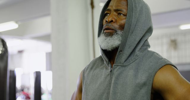 Senior Man in Grey Hooded Vest Focused During Gym Workout - Download Free Stock Images Pikwizard.com