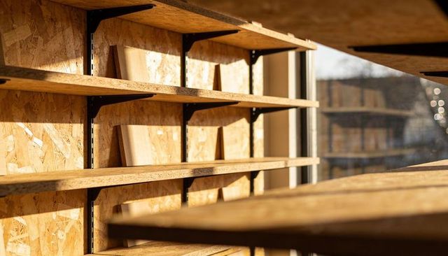 Showcasing sunlit osb workshop shelving with metal brackets and urban window light