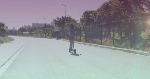 Woman Riding Electric Scooter on Urban Street