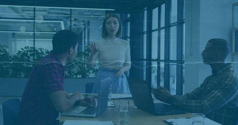 Asian Woman Leading Team Meeting in Bright Office Presenting Ideas with Laptops