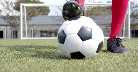 Soccer Player Kicking Ball Near Goal