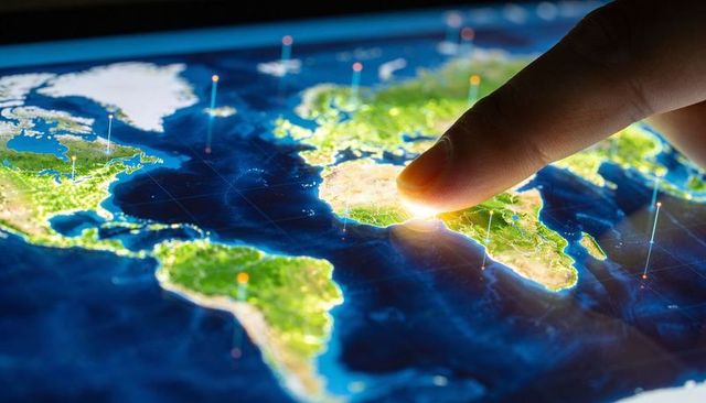 Tapping fingertip on glowing digital map pinpointing global data hubs and network links