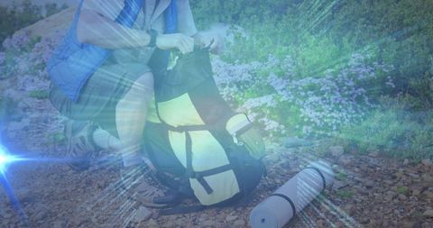 Hiker with backpack and sleeping pad on mountain trail