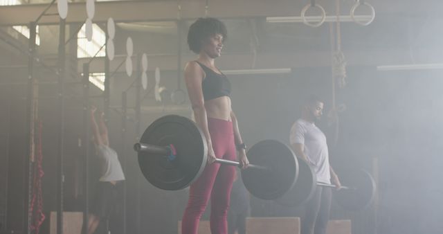 Focused biracial sports people exercising and lifting weight bars at gym - Download Free Stock Photos Pikwizard.com