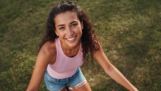 Smiling young woman enjoying sunny day on lawn