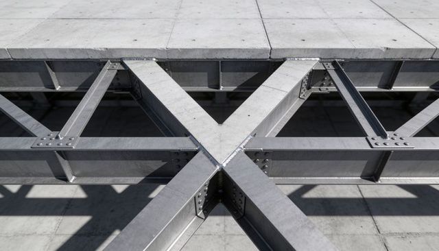 X-brace steel truss junction highlighting bolted plates, rivets and welds under concrete slab