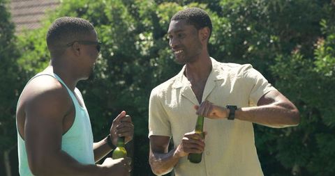 Friends Socializing Outdoors, Enjoying Drinks in Sunny Backyard