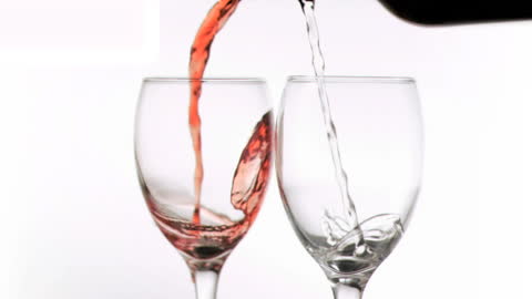 Red and White Wine Pouring Simultaneously into Clear Glasses