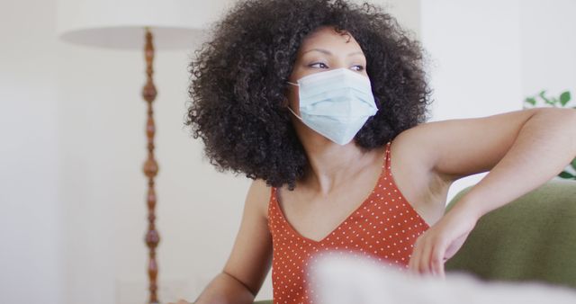 Woman Wearing Face Mask Sitting on Couch at Home - Download Free Stock Images Pikwizard.com