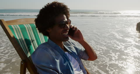 Relaxing Young Man Chatting by the Ocean