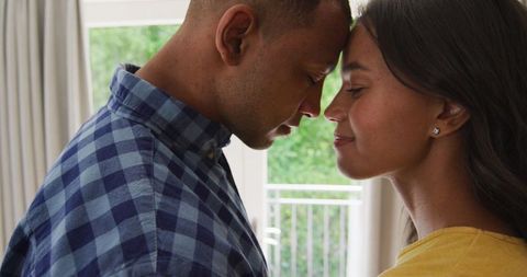 Loving Biracial Couple Embracing at Home with Smiles
