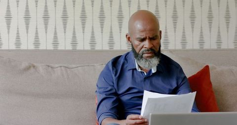 African American Man Analyzing Documents at Home