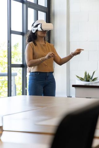 African american woman experiencing virtual reality with white headset in modern office