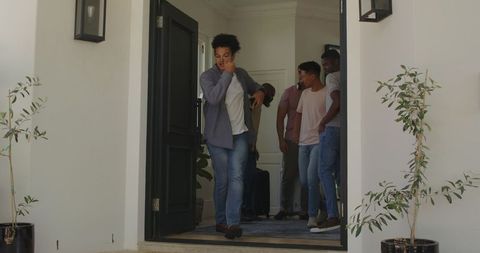 Friends Exiting House Cheerfully Portraying Excited Anticipation