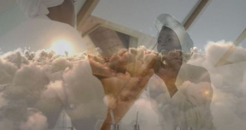 African american woman removing makeup amidst clouds symbolizing serenity