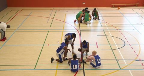 Basketball Players Strategizing on Gym Court in Huddle