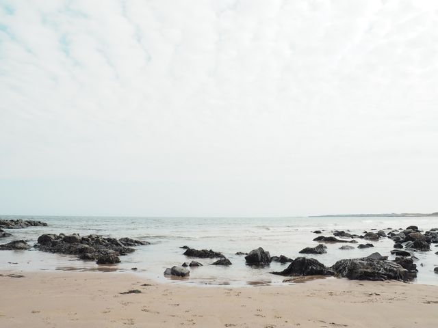 Serene cloudy beach with rocky shoreline - Download Free Stock Photos Pikwizard.com