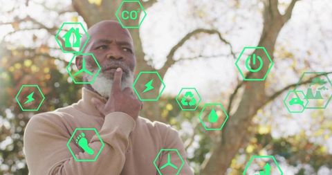 Thoughtful Middle-Aged Man Surrounded by Eco-Friendly Icons Outdoors