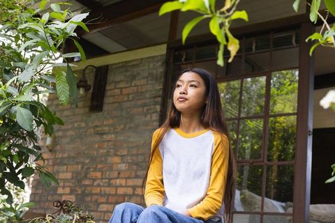 Teen girl in rustic outdoor setting relaxing in natural surroundings