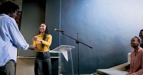Businesswoman Delivering Presentation to Rapt Audience in Modern Office