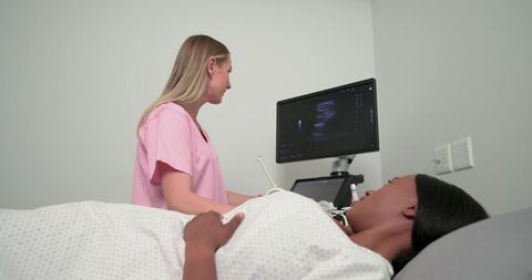 Prenatal abdominal ultrasound exam with sonographer viewing monitor, patient on exam table