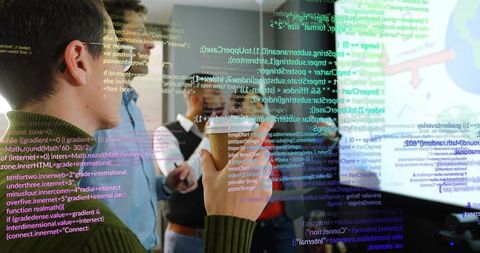 Team analyzing code display for innovative solutions