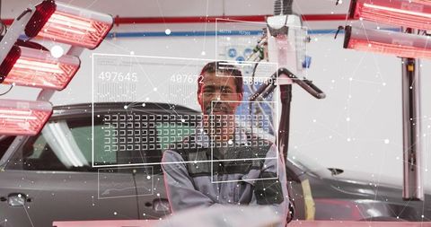 Autobody technician using infrared curing lamps for car repair with hud diagnostics