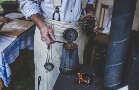 Man Brewing Coffee on Outdoor Stove Showing Rustic Cooking
