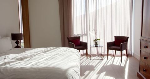 Sunlit Modern Bedroom with Sheer Curtains and Cozy Chairs - Download Free Stock Images Pikwizard.com