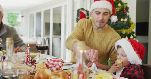 Family Celebrating Christmas With Festive Dinner, Father and Child Wearing Santa Hats - Download Free Stock Images Pikwizard.com