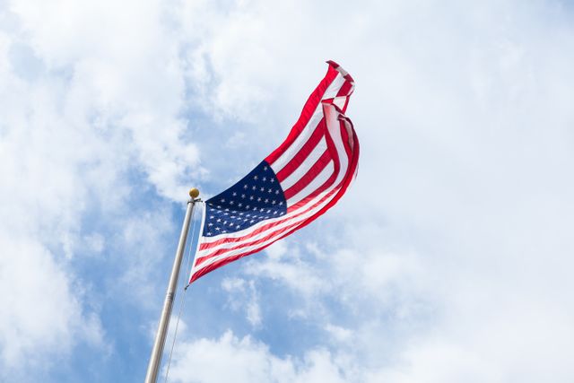 American Flag Waving on Pole Against Blue Sky with Clouds - Download Free Stock Photos Pikwizard.com