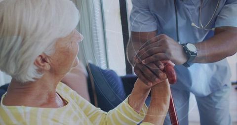 Male nurse holding and supporting senior woman hand with cane showing compassionate caregiving