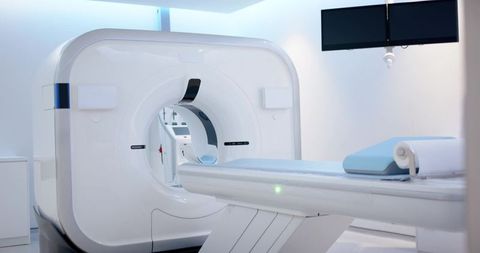 Modern ct scanner room featuring motorized patient table and blue head cushion