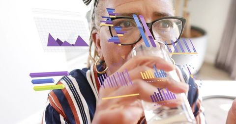 Senior woman drinking water and reviewing data visualizations overlaid on portrait