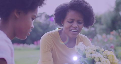 African American Mother and Daughter Gardening in Yard