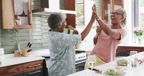 Joyful Senior Friends Cooking Together in Modern Kitchen